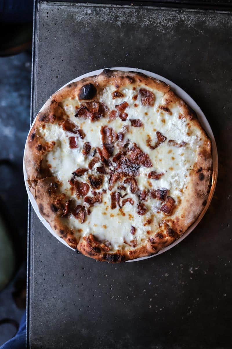 Wood-fired crust topped with crimini mushrooms, fresh mozzarella, and housemade sausage by Delancey