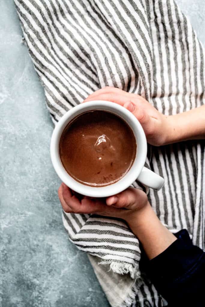 small child's hands holding a mug of Italian hot chocolate