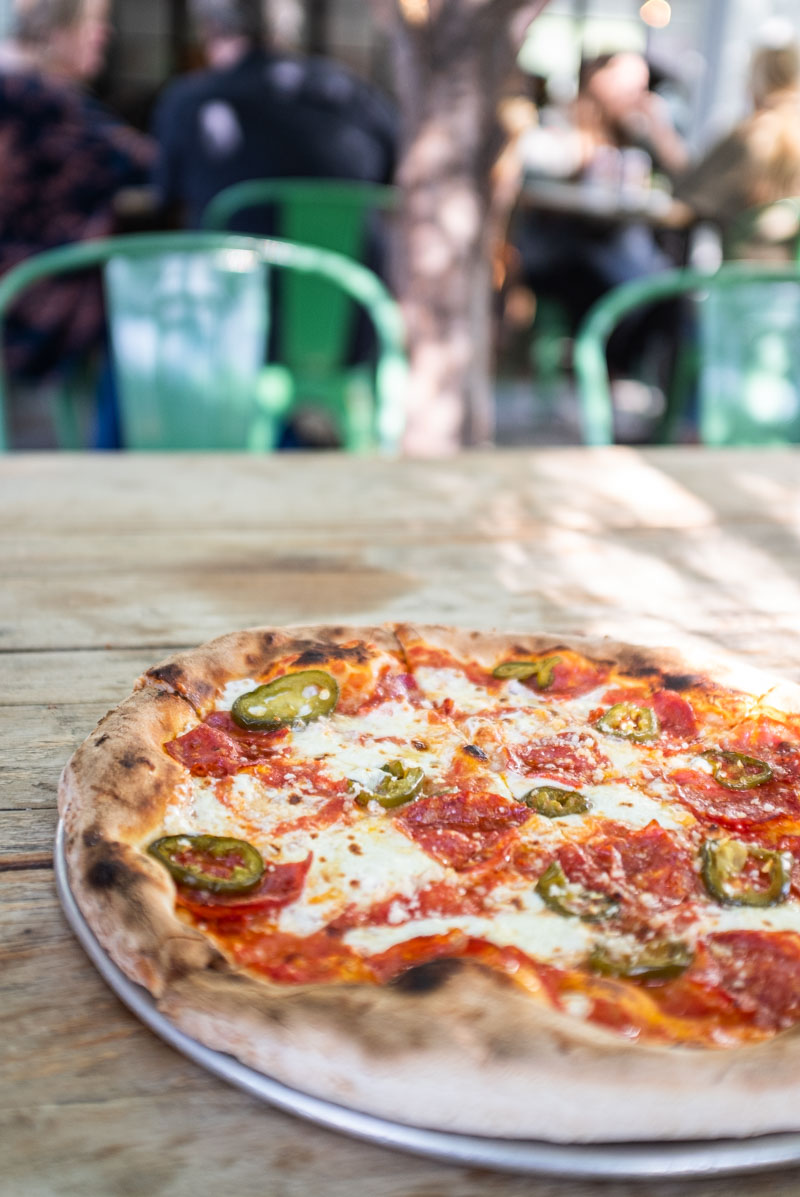 Beehive by Pizza Nono. A classic marinara pizza with mozzarella, calabrese, and grana loaded with pickled jalapenos and hot honey drizzled over the top.