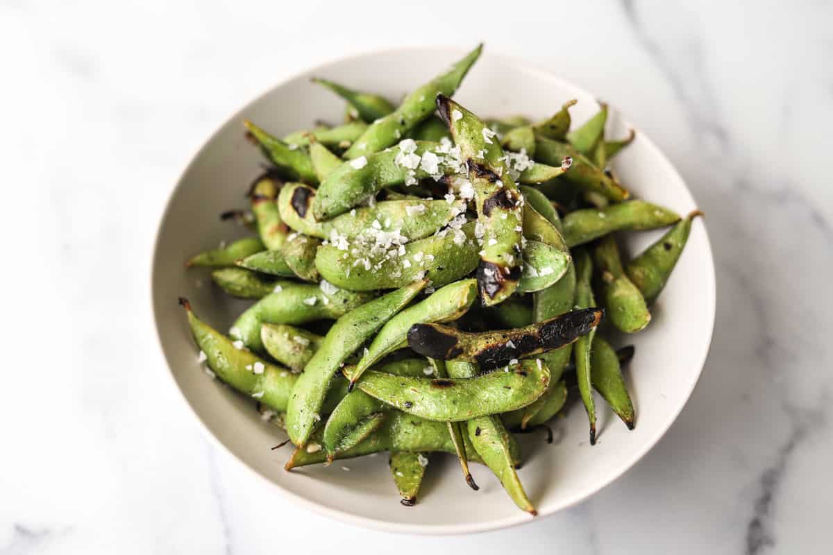 horizontal photo of grilled edamame in bowl