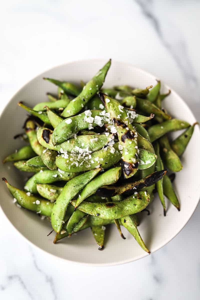 close up shot of grilled edamame with flaky sea salt