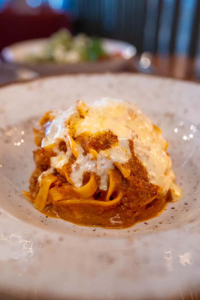 tagliatelle served with wagyu bolognese sauce, bits of pancetta, and topped with a gooey, cheesy, fontina fondue by Mora Italian