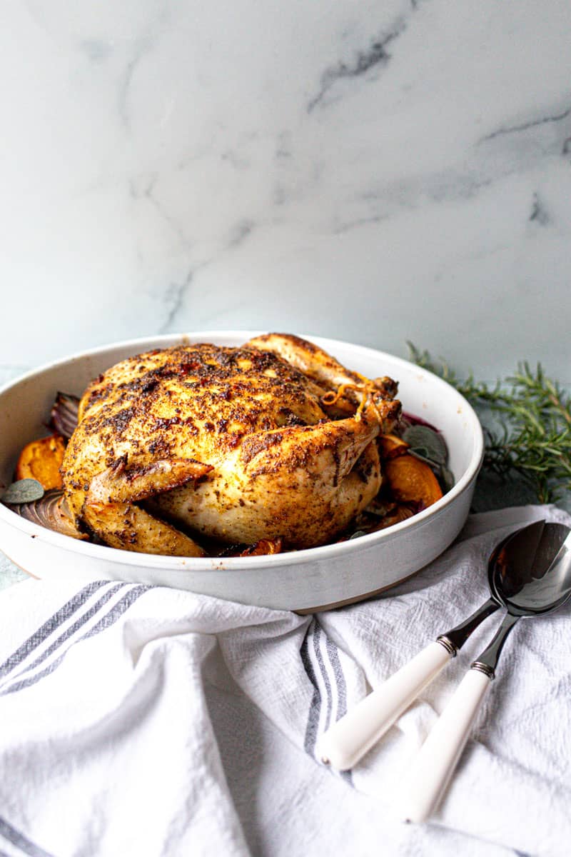 Thanksgiving chicken in pan with serving utensils