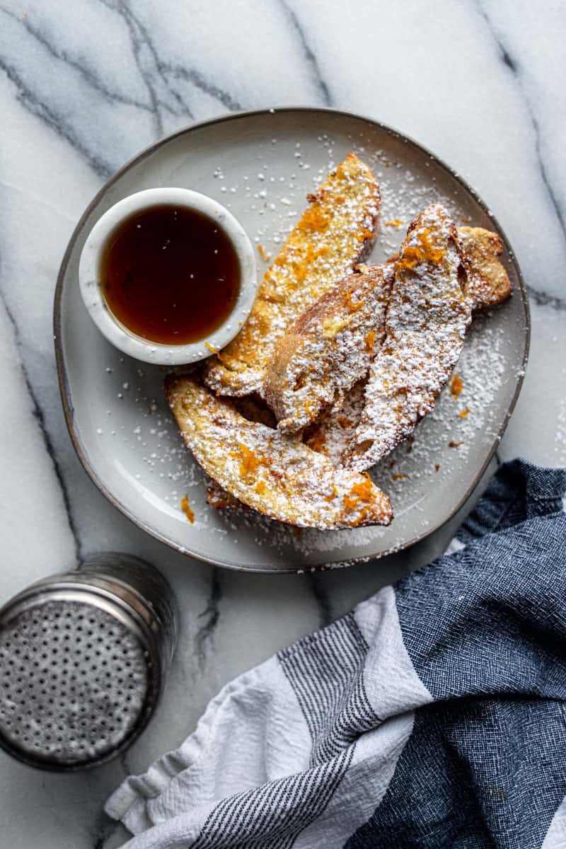 air fryer french toast sticks with small bowl of maple syrup